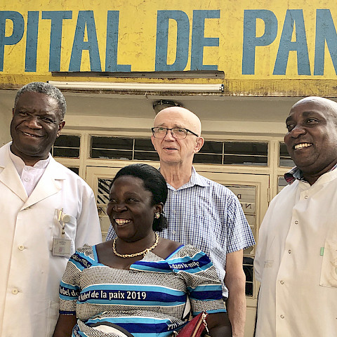 Kirurgikollegat Veikko Reinikainen ja Denis Mukwege sekä Panzin sairaalan henkilökunta tapasivat syyskuussa 2019 uudelleen sairaalan ensimmäisen asiakkaan Mapatanon. Reinikainen leikkasi hänet vanhassa huvilassa vuonna 1999 paikassa, johon perustettiin Panzin sairaala. Mapatano oli tuolloin vakavasti loukkaantunut väkivaltaisen raiskauksen uhrina, ja hänen selviämismahdollisuutensa eivät olleet suuret. Leikkausvälineet steriloitiin kattilassa keittämällä, kun muita sterilointivälineitä ei vielä ollut. Mapatano kertoi, että nyt hän kulkee nyt potilashuoneissa rohkaisemassa muita  ihmeitä tapahtuu ja toivoa on! Kuva: Fida / Hannu Happonen.