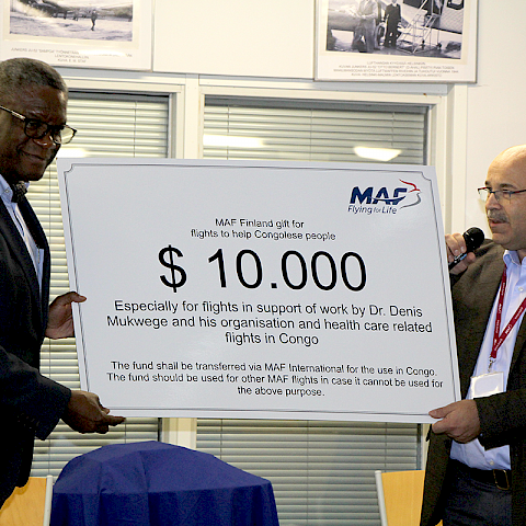 Dr. Mukwege ja hänen puolisonsa Madeleine saapuivat Malmin lentokentälle, jossa toimii mm. MAF (Mission Aviation Fellowship). Se on vuonna 1945 perustettu maailmanlaajuinen kristillinen järjestö, joka operoi pienlentokoneita kehitysmaissa alueilla, joissa etäisyydet ovat pitkiä, maantiet puuttuvat tai ne ovat vaikeakulkuisia ja turvattomia. Monet kehitysyhteistyö- ja lähetysjärjestöt sekä kansainväliset avustusjärjestöt kuten YK:n lastenapu, maailman ruokapankki ja terveysjärjestö WHO käyttävät MAF:n palveluita mm. terveydenhuollon ja perusopetuksen hankkeissa. Suomessa MAF kouluttaa lentäjiä Malmin lentoasemalla. Mukwege kertoi lähetyslentäjien pelastaneen hänen ja hänen perheensä hengen vuonna 1996 lennättämällä heidät turvaan taistelujen keskeltä. Suomen lähetyslentäjien toiminnanjohtaja Janne Ropponen luovutti Dr. Mukwegelle 10.000 dollaria tukemaan tämän työtä.  Varoja on tarkoitus käyttää raiskausten uhrien lentämiseksi hoitoon sekä Mukwegen tiimien lentämiseksi levottomuuksista ja huonoista tieyhteyksistä kärsivillä. Kuva: Thorleif Johansson.