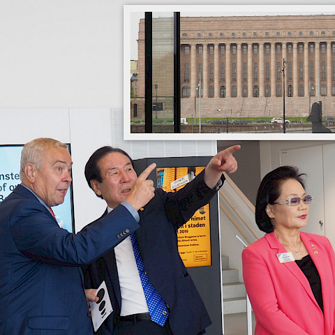 Kv-presidentti Choi ja PID Harri Ala-Kulju osoittavat yhtäaikaisesti, kuinka Oodin julkisivun ikkunasta on suora näkymä eduskuntataloon. @Antti Tuomikoski